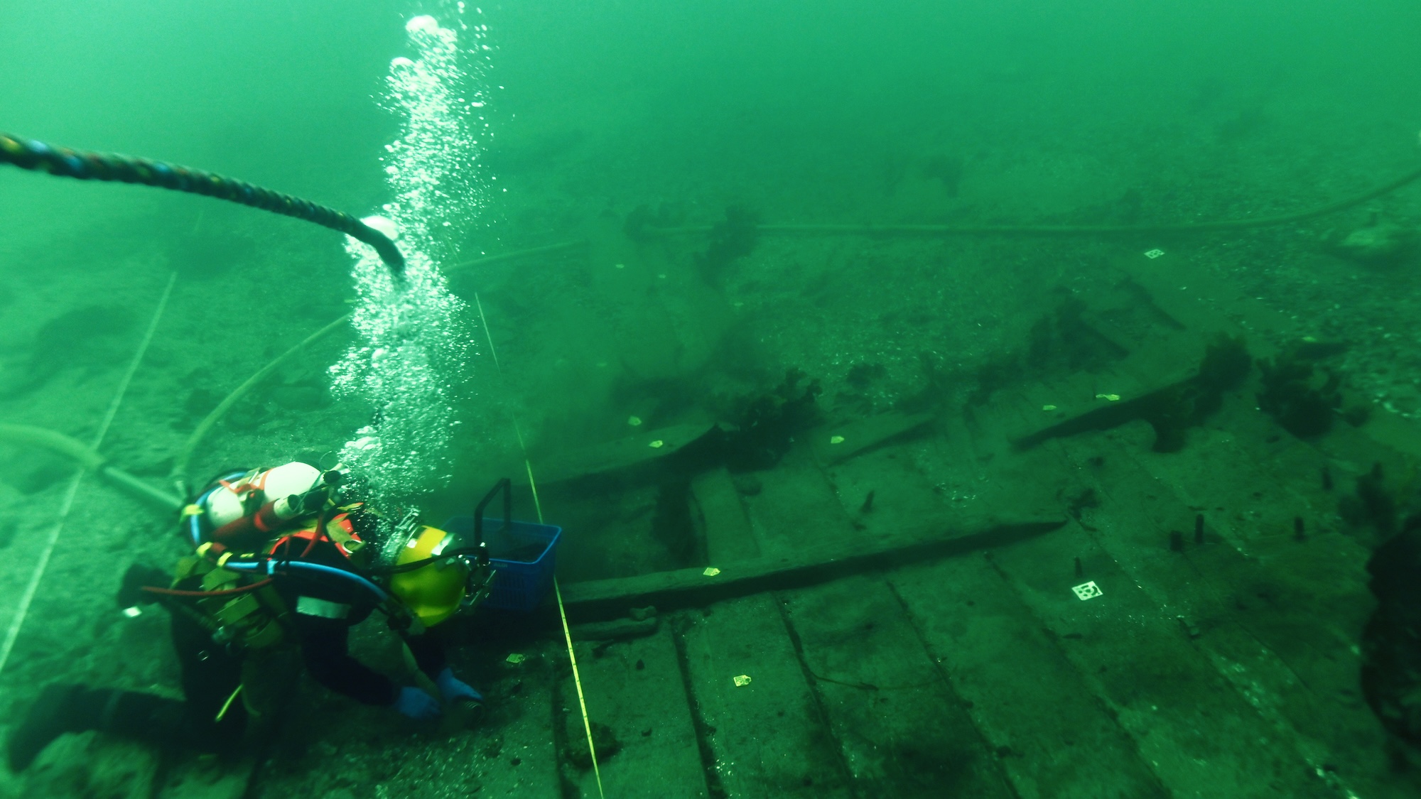 Diver underwater investigating Viking shipwreck