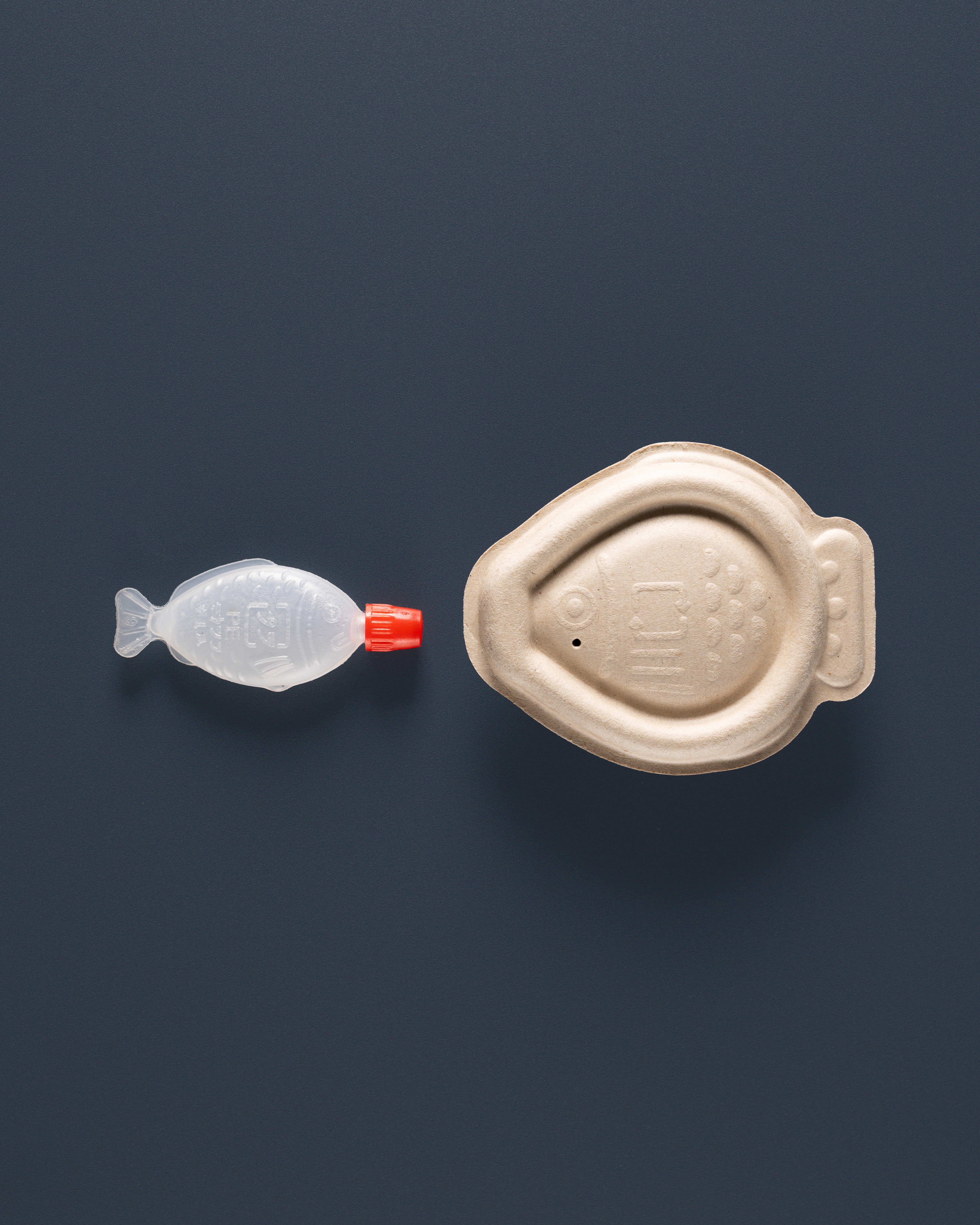 Plastic-free soy sauce container biodegrades in 4 weeks插图 A traditional plastic fish-shaped soy sauce container (left) with the new biodegradable option (right).