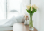 an empty hospital bed with flowers by a table