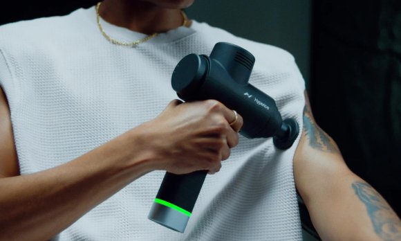 A person using a Hypervolt percussion massager