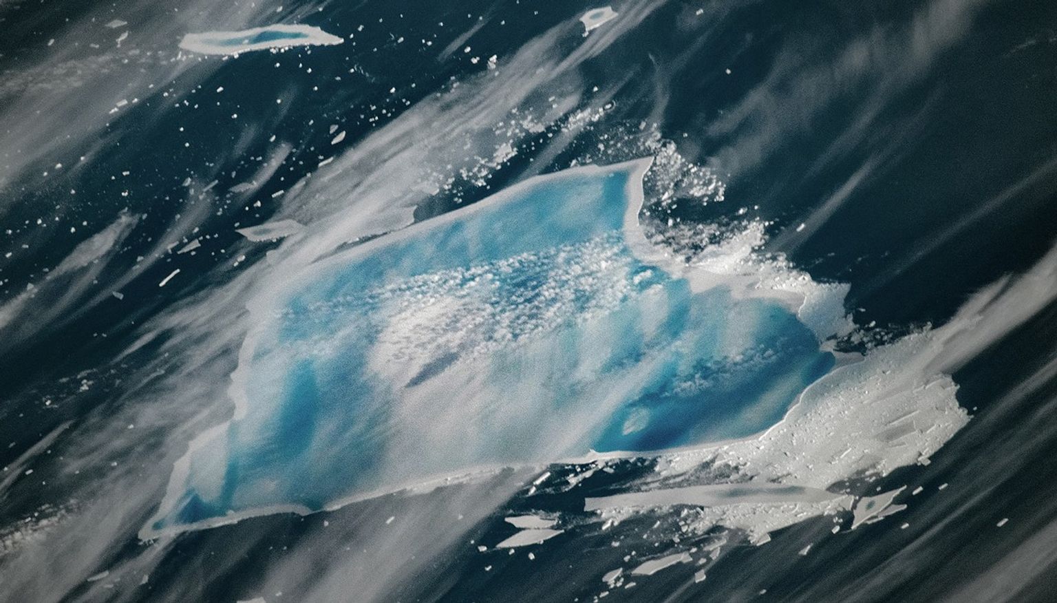 Why is this infamous iceberg turning blue?插图1 A satellite image of an iceberg taken showing blue pools of water