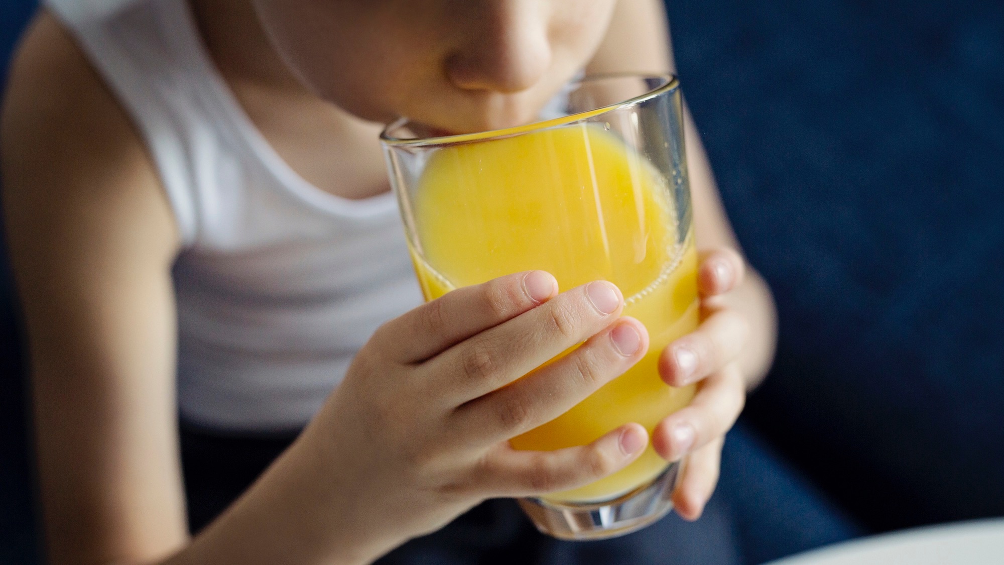 Little boy drinking orange juice