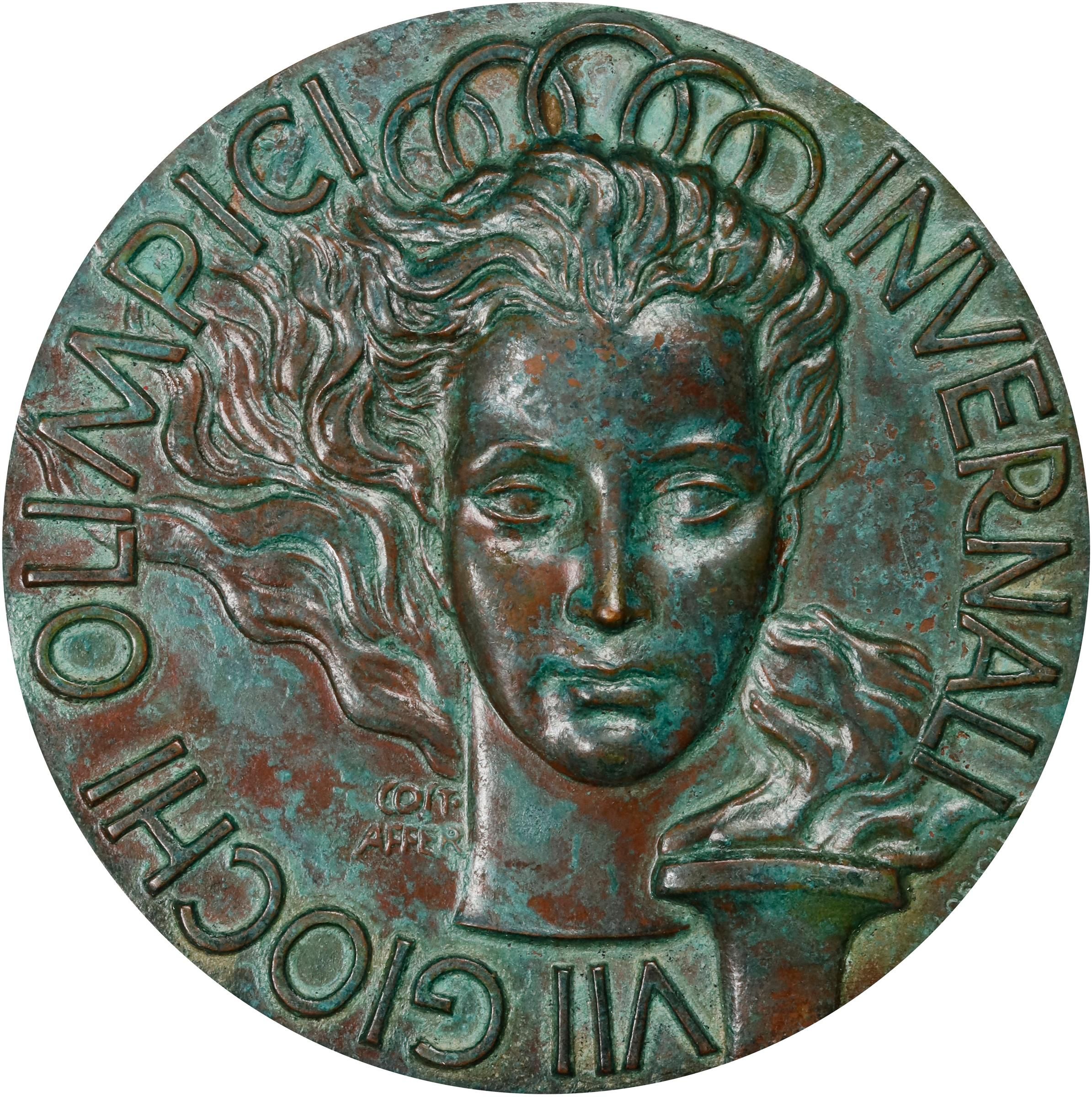 a medal from the 1956 winter olympics showing a goddess with hair waving