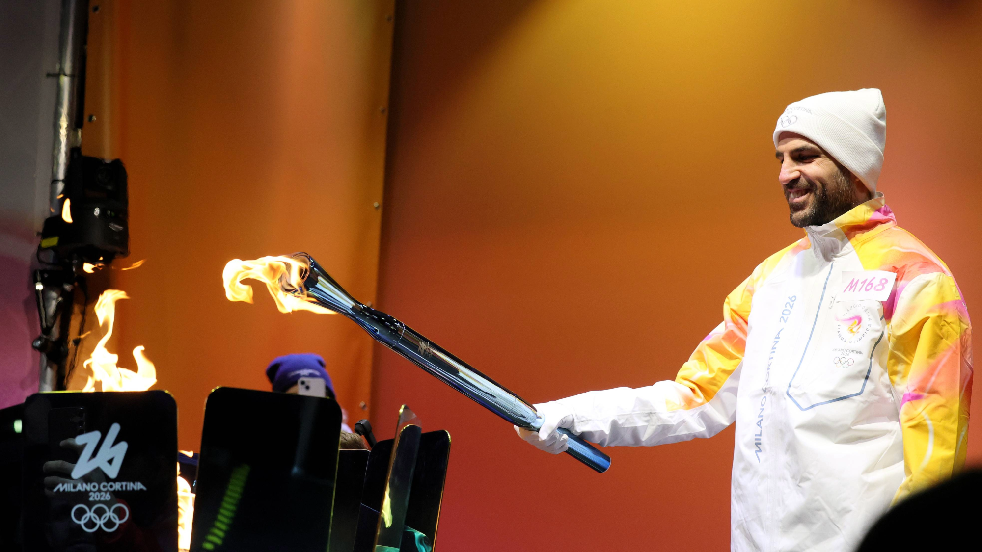 a man holds a light blue torch and a flame