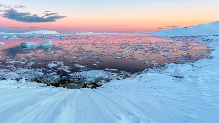The Midnight sun over the icebergs in the Weddell Sea from the Antarctic Peninsula in Antarctica.