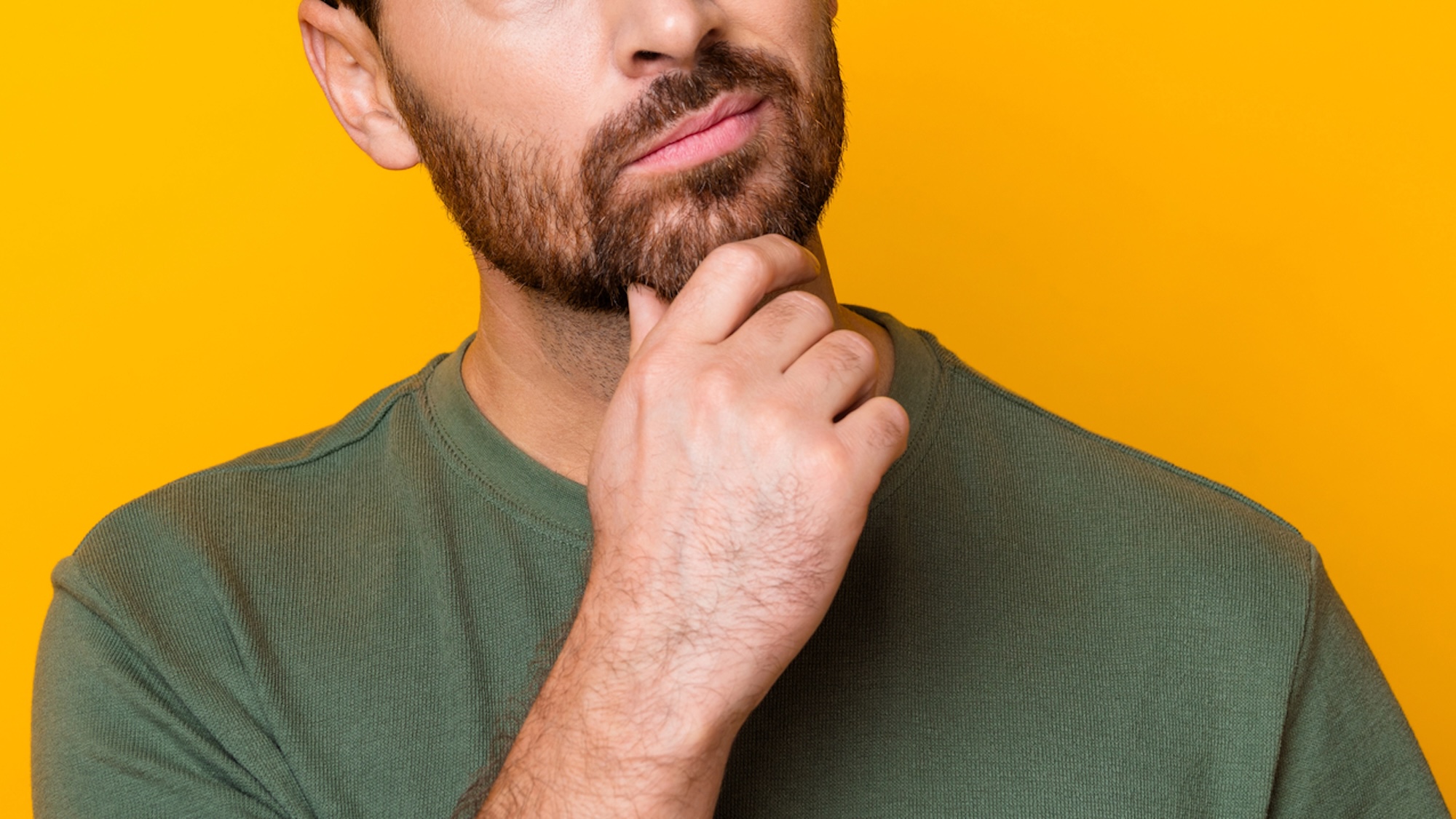 Close up of man's hand on chin while he's thinking