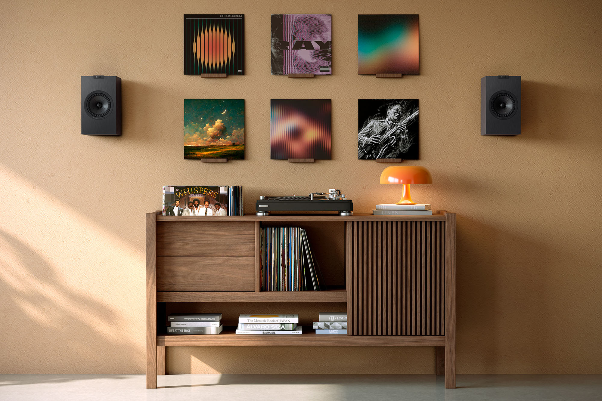 Two satin black KEF Q4 Meta on-wall speakers flanking vinyl album artwork hung over a credenza with a turntable on it.