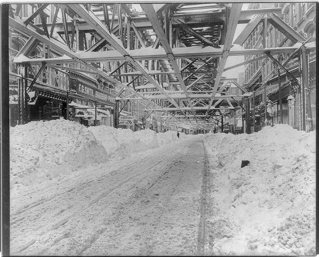 雪の中から道路が掘られ、その上に高架線が通っている