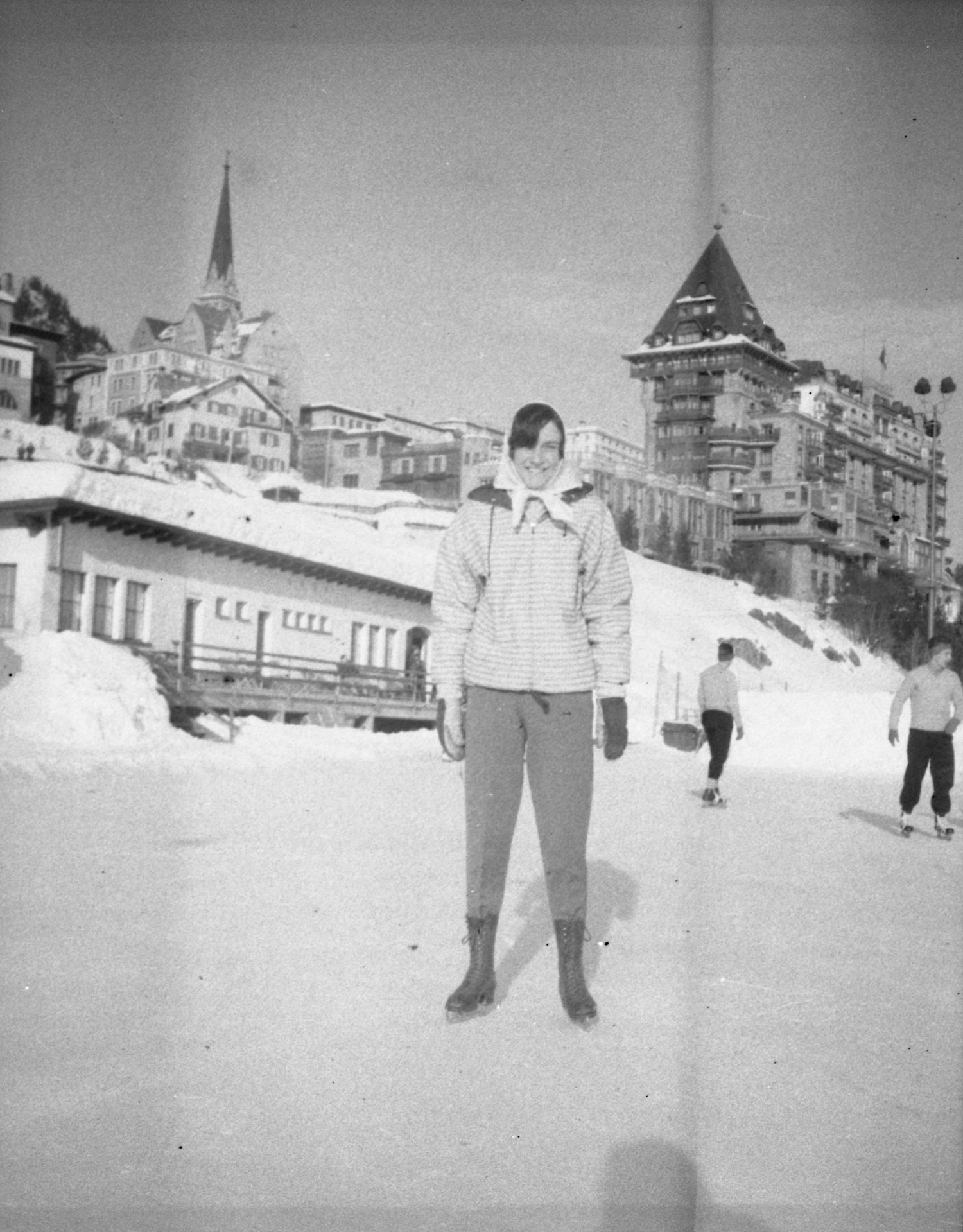 Young person in ski attire standing outside hotel in Swiss Alps