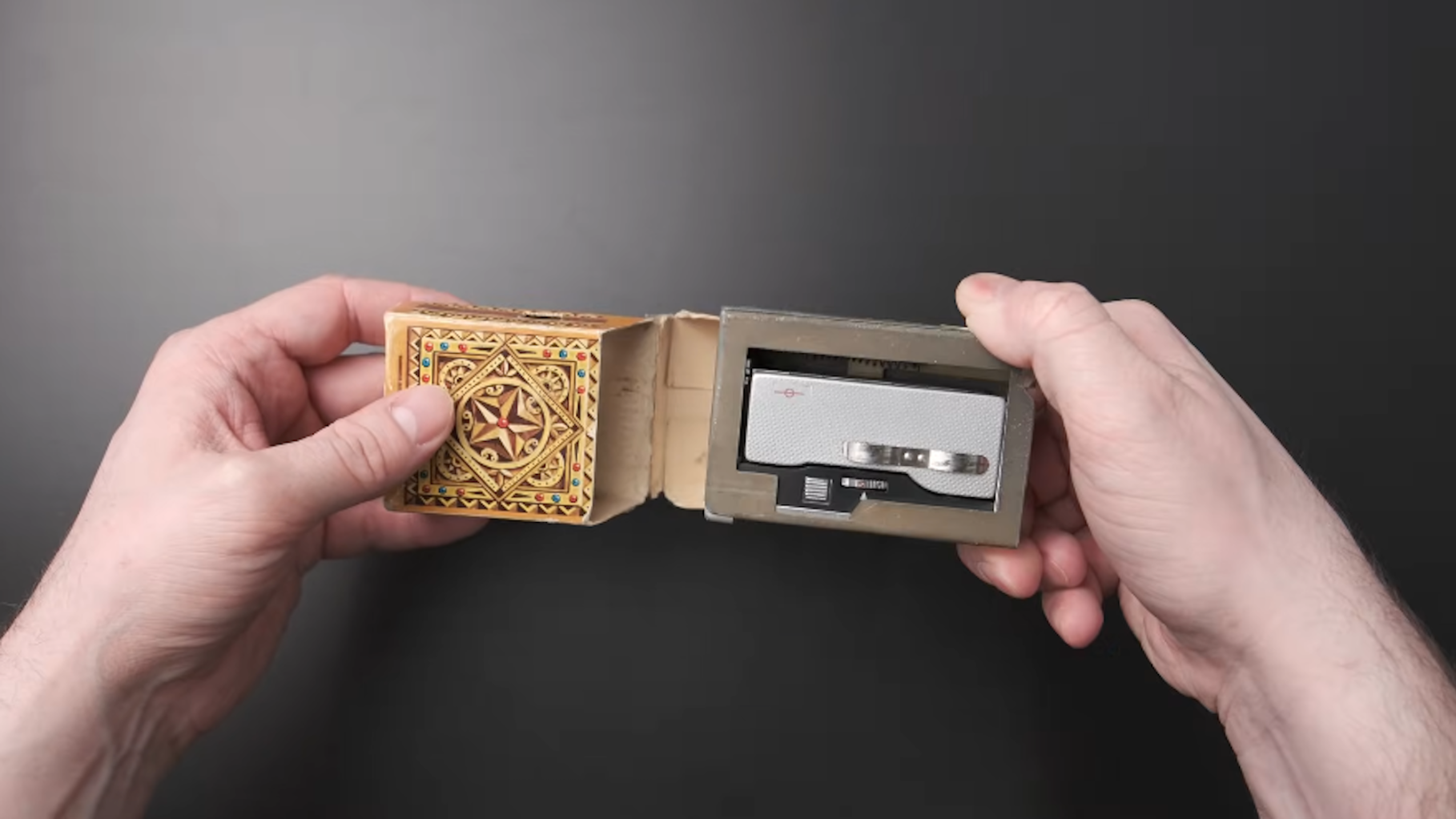 Hands holding a camera that is housed inside a cigarette case