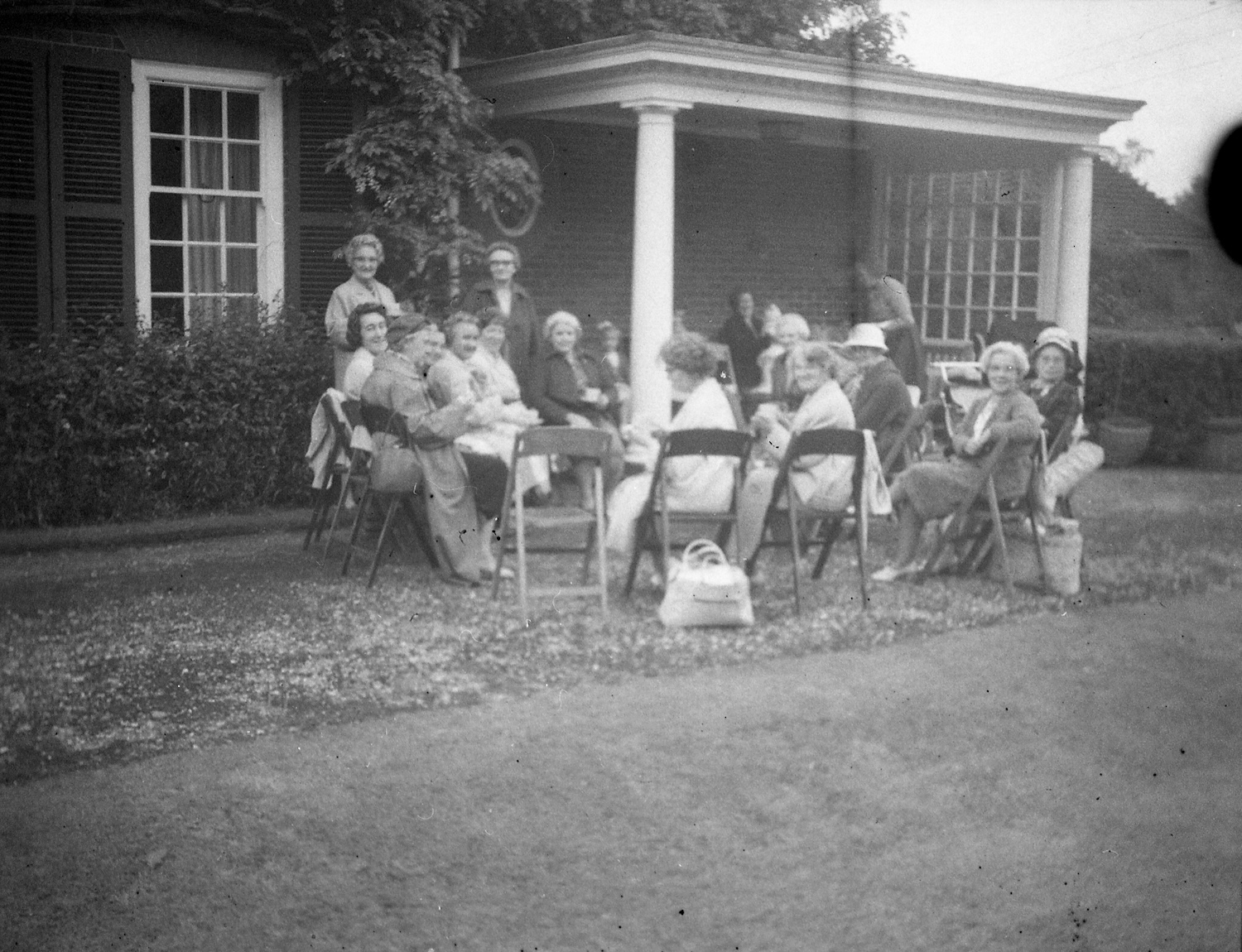 Women sitting in a garden party circle outside a home in the UK