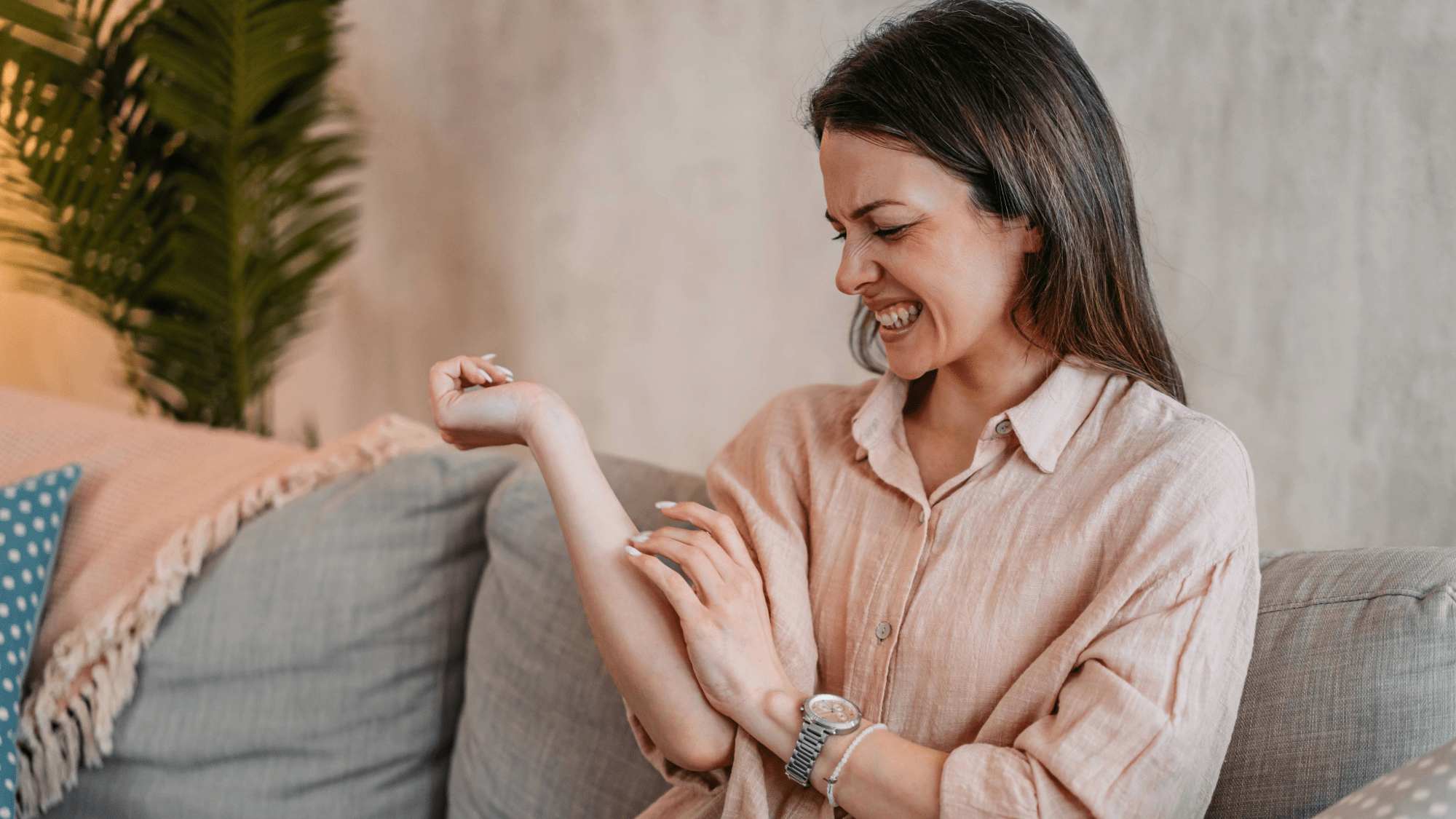 a woman scratches an uncomfortable itch on her forearm