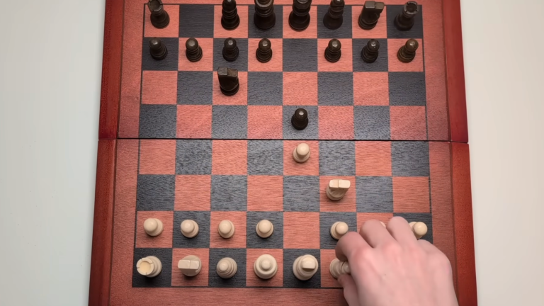 a hand moves pieces on a brown and black chess board