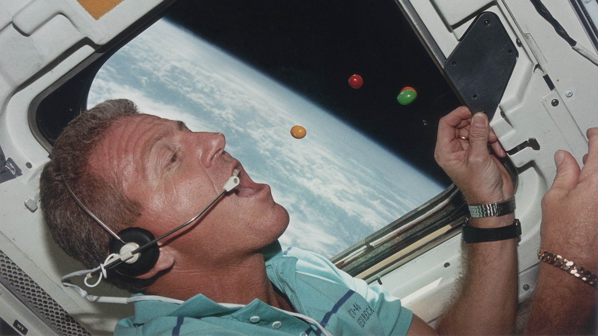 Astronaut Loren J. Shriver, Mission Commander of STS-46, attempts to eat floating sweets on the flight deck of the shuttle Atlantis during its orbit of the earth, August 1992. (Photo by Space Frontiers/Getty Images)