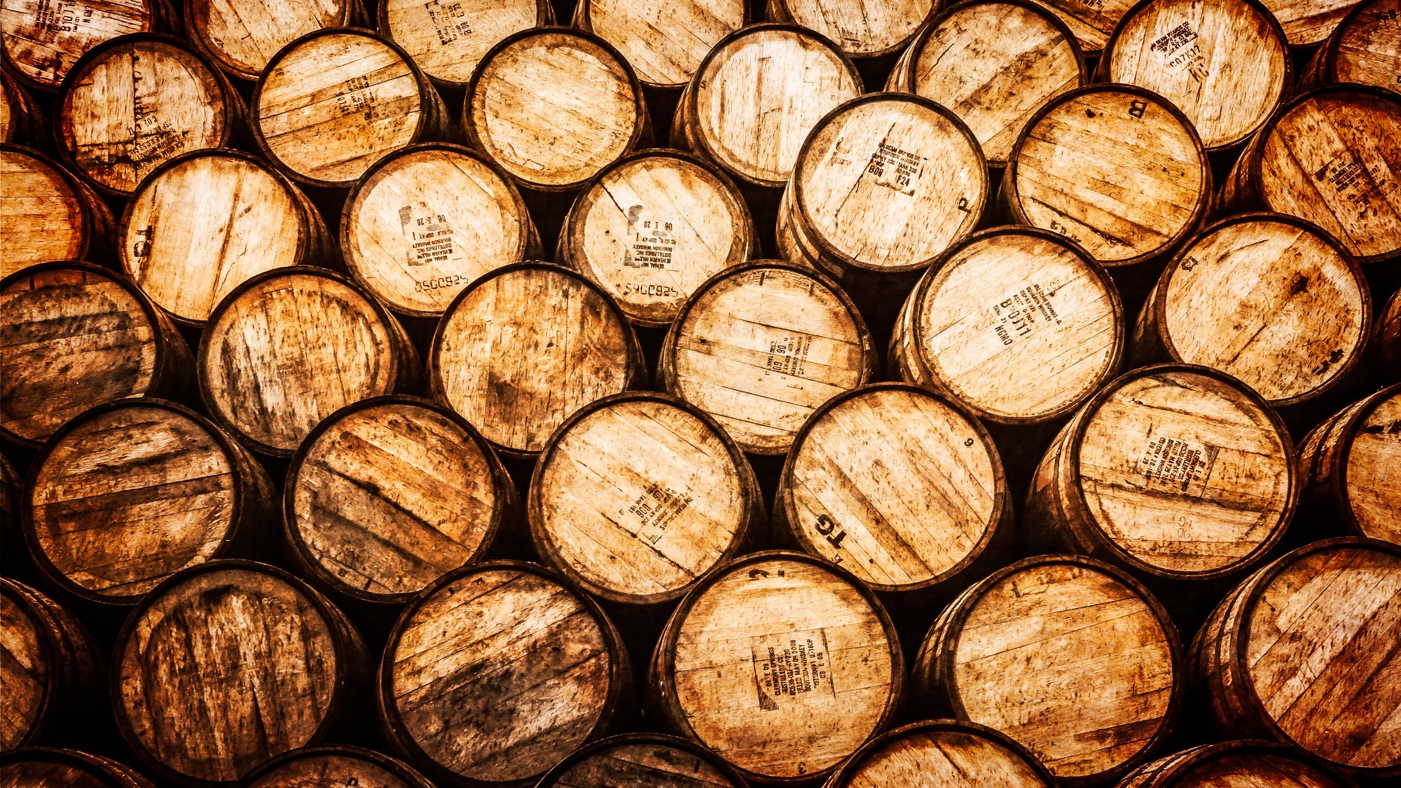 Detail view of stacked whisky and wine wooden barrels in vintage style