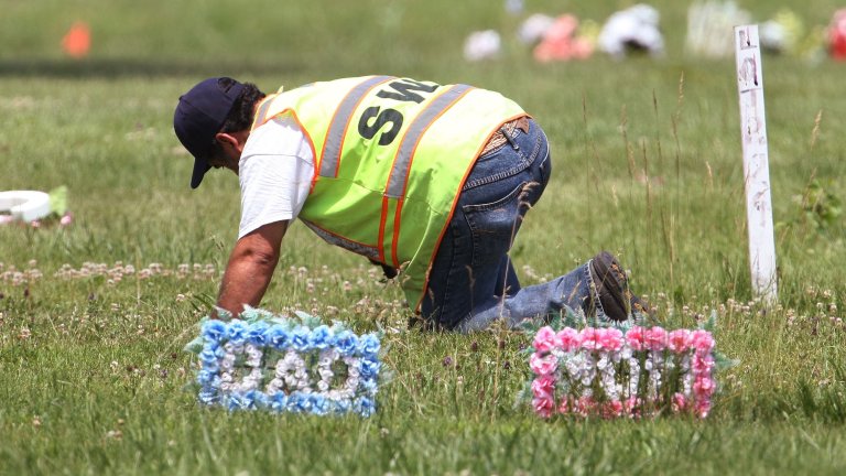A worker searches for evidence at Burr Oak Cemetery July 14, 2009 in Alsip, Illinois. Police recently closed the cemetery declaring the site a crime scene after human remains were found on the ground at various locations in the cemetery. Police suspect hundreds of graves could have been dug up in the historic black cemetery over the last several years and the bodies dumped elsewhere on the grounds in order for the gravesites to be resold by the cemetery management. Blues music legend Willie Dixon and civil rights figure Emmett Till are among those buried in the suburban Chicago cemetery. The First Lady's office confirms that Michelle Obama's father, Fraser Robinson, is also buried there. (Photo by Scott Olson/Getty Images)