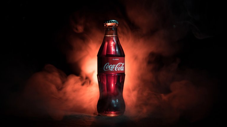 Baku, Azerbaijan 13th January 2018, Coca-Cola Classic in a glass bottle on dark toned foggy Background. Coca Cola, Coke is the most popular carbonated soft drink beverages sold around the world