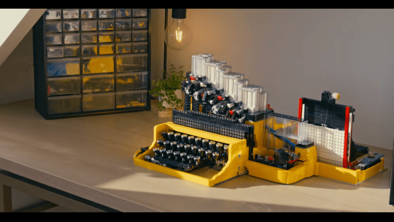 A DIY Lego mechanical typewriter sitting on a desk