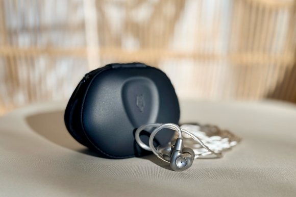 The Meze Audio ASTRU IEM sitting in front of its hardcase on a sunlit chair