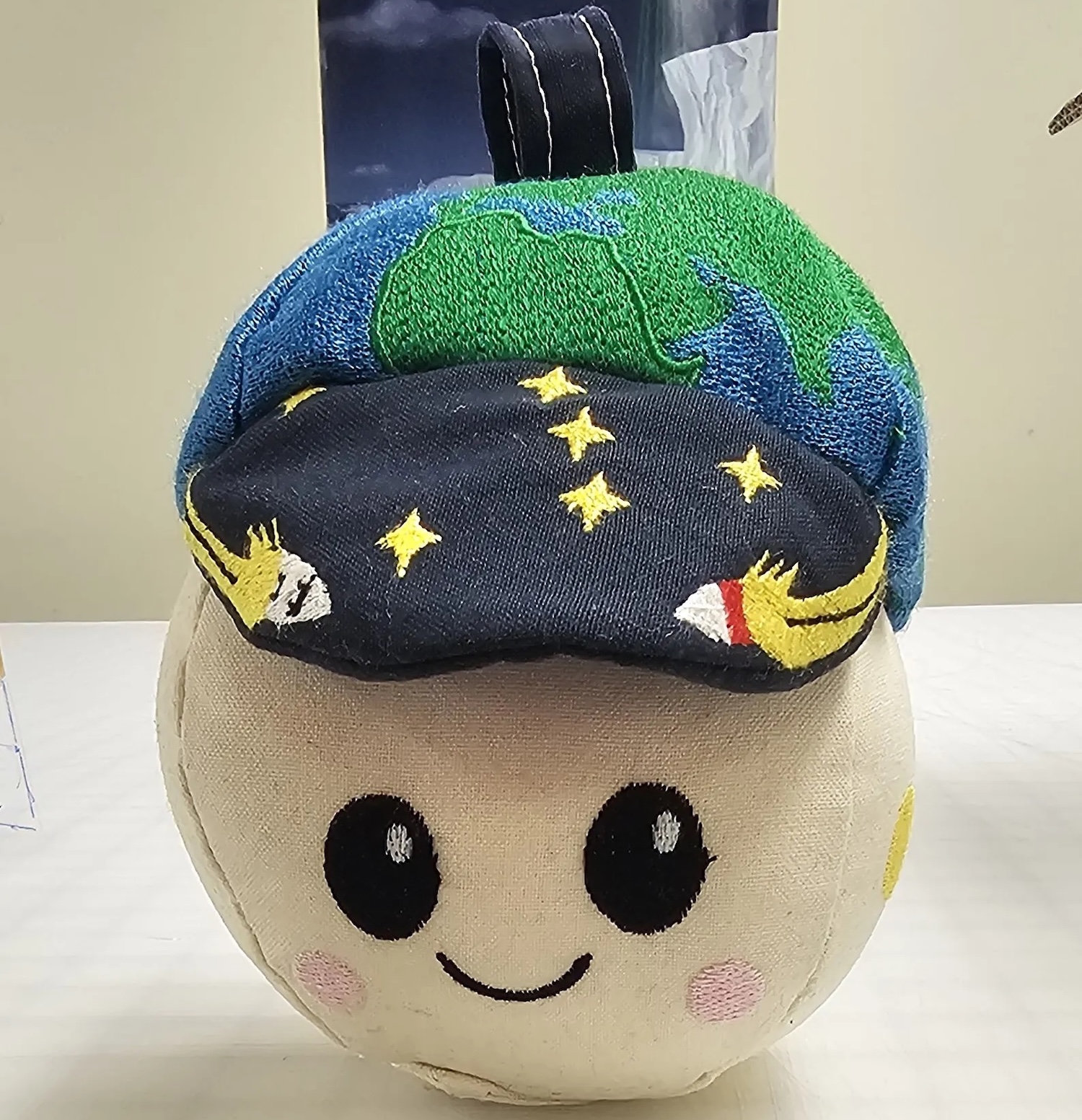 “Rise,” designed by Lucas Ye of Mountain View, California, as the zero gravity indicator that will fly with the crew around the Moon. “Rise” was inspired by the iconic Earthrise moment from the Apollo 8 mission. A zero gravity indicator is a small plush item that typically rides with a crew to visually indicate when they are in space.
