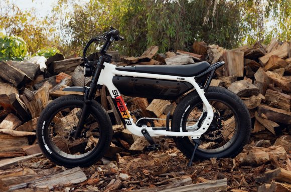 The new SUPER73 A-Series M1D electric bike parked in front of a stack of chopped firewood