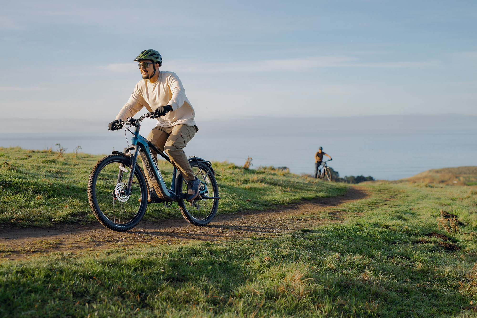 Two dudes riding the Velotric Summit 2 multi-terrain ebike along a ridge line
