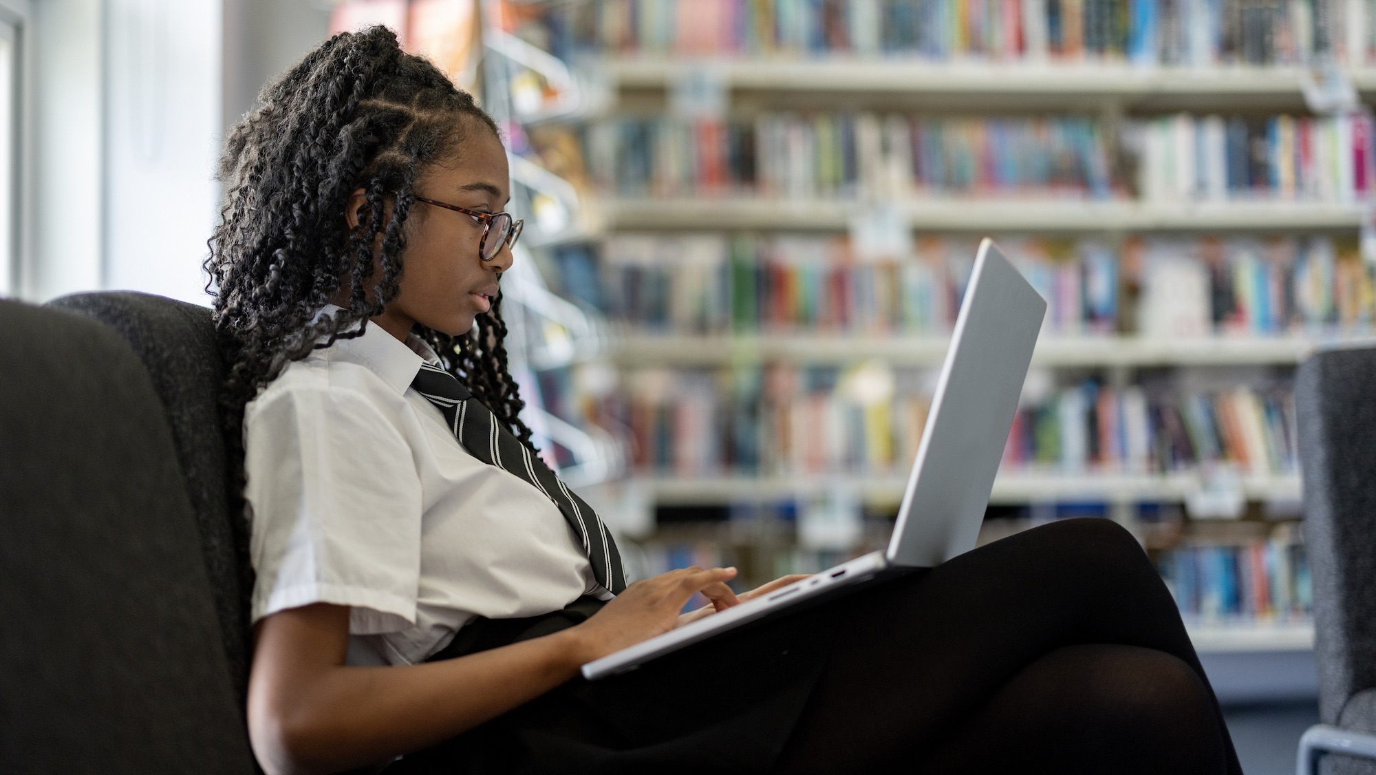 Teenage high school student studying alone in the school library