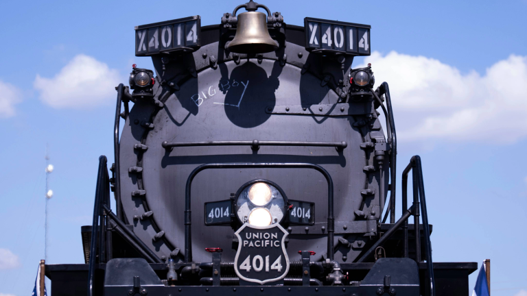 the front of a steam locomotive. it is black and reads "union pacific 4014"
