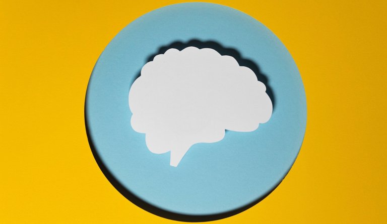 Human brain made fo paper on a yellow round background
