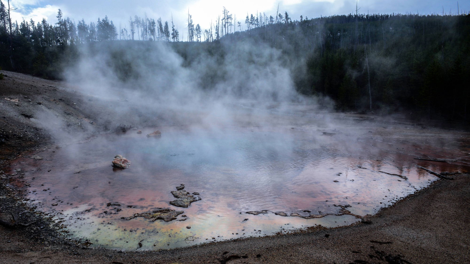 a large pool of water with smoke rising from it