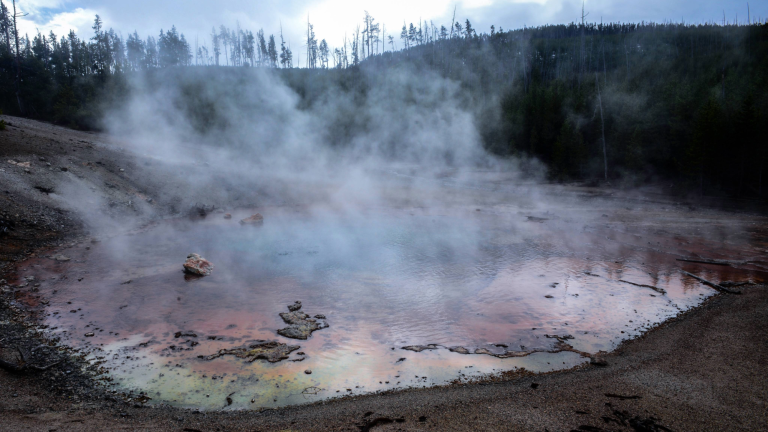 a large pool of water with smoke rising from it