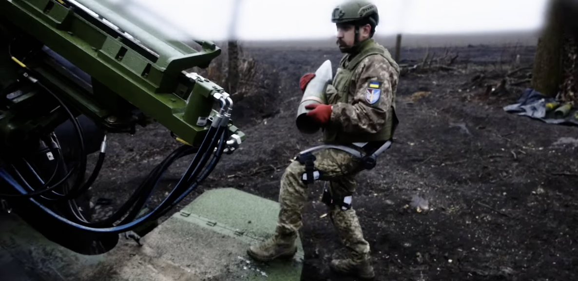 a soldier loading an artillery shell