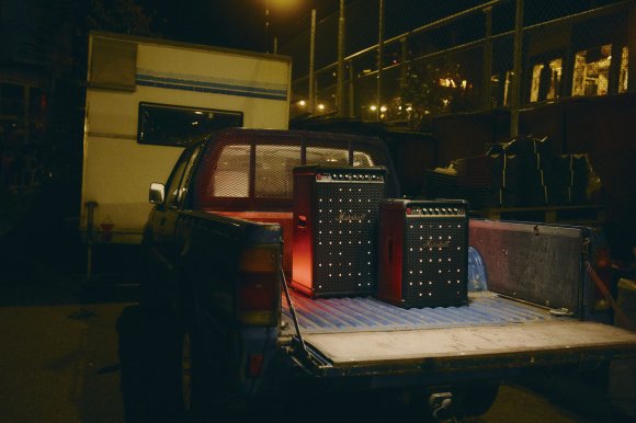 A Marshall Bromley 450 portable Bluetooth speaker sitting in front of a Bromley 750 transportable Bluetooth speaker in the flatbed of a pickup truck