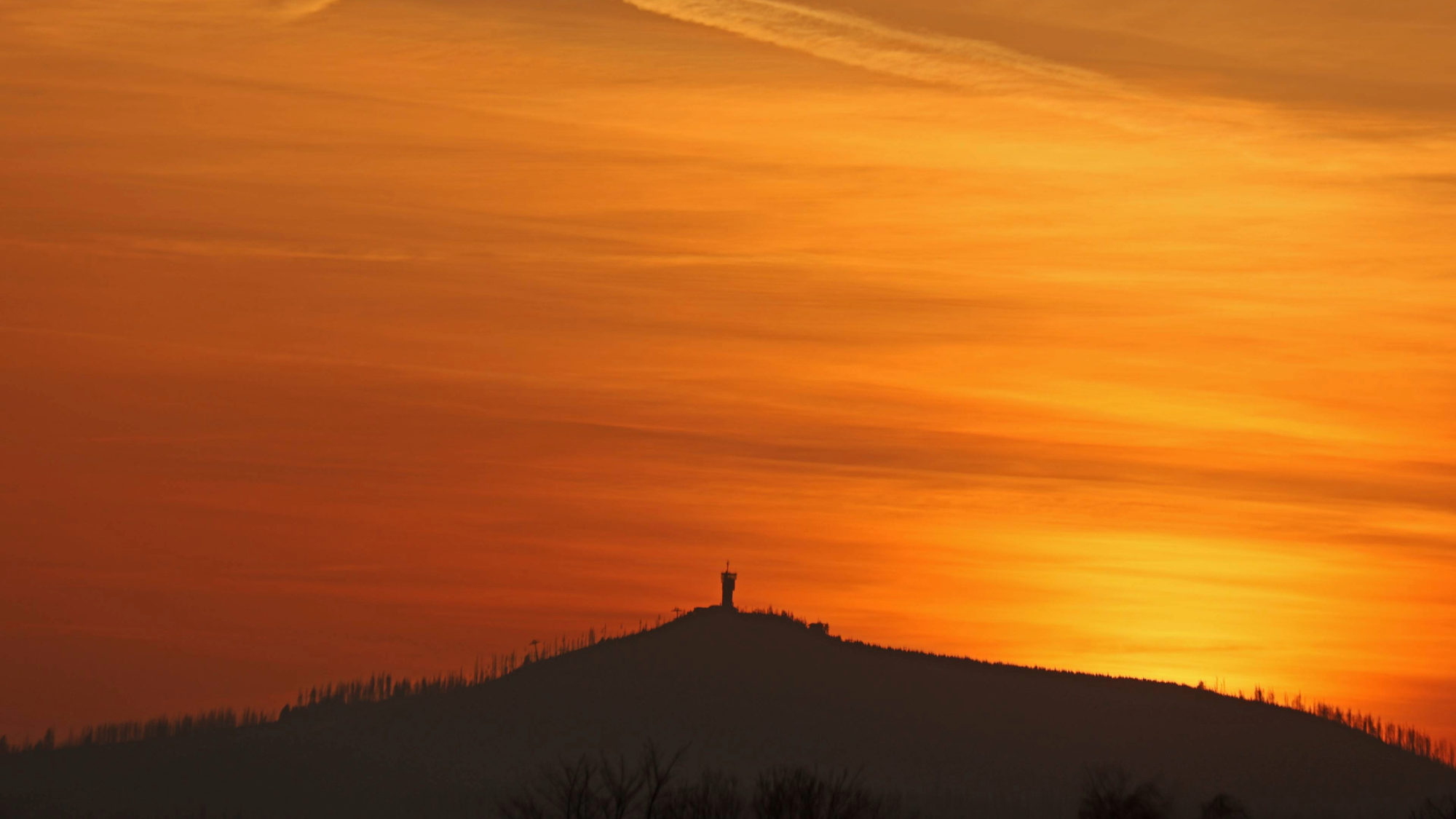 In the light of the setting sun, the sky forms a veil of Saharan dust over the Wurmberg in Lower Saxony, Germany. The Sahara dust colors the sky red.