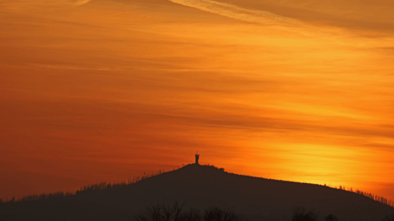 In the light of the setting sun, the sky forms a veil of Saharan dust over the Wurmberg in Lower Saxony, Germany. The Sahara dust colors the sky red.