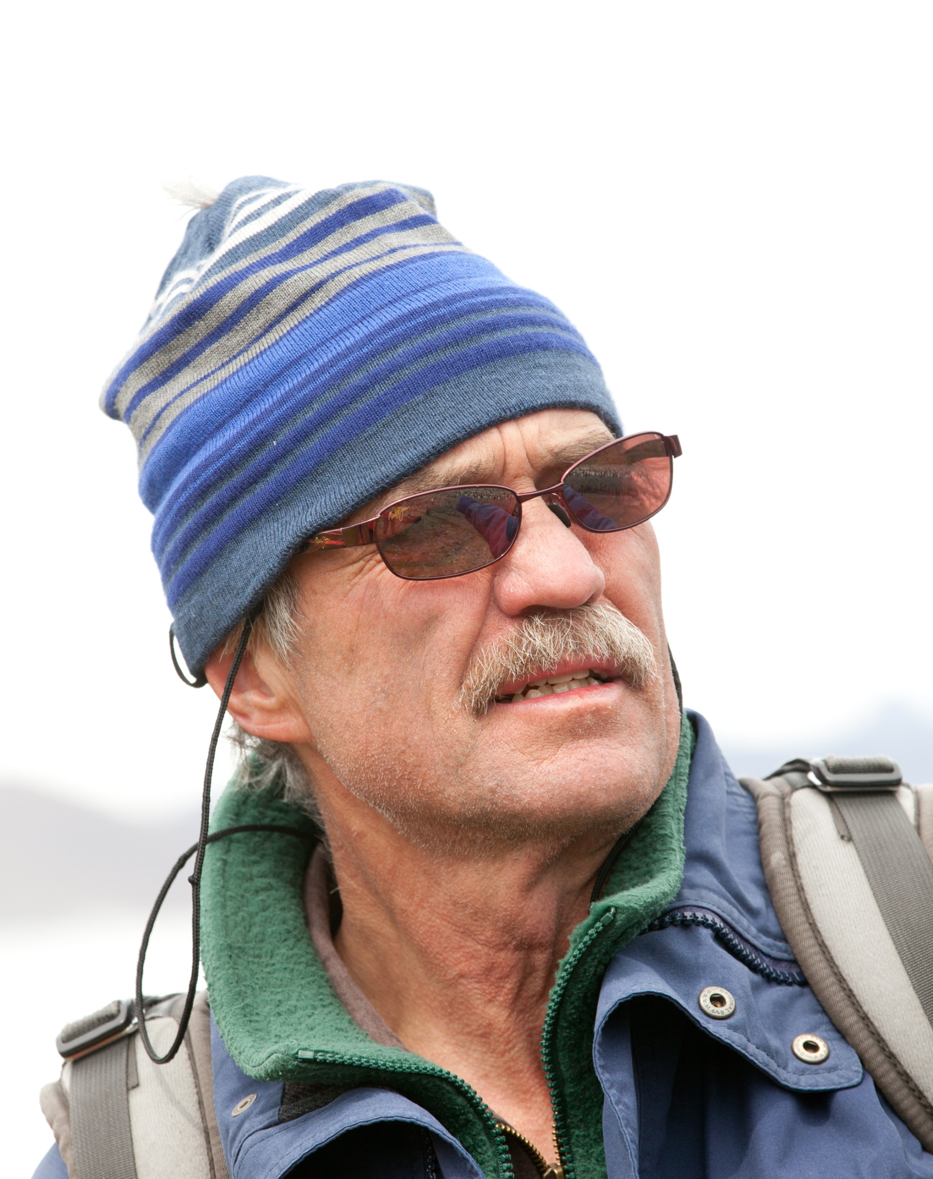 a man with a white mustache, sunglasses, and a hat