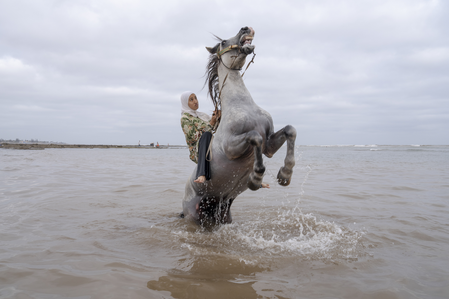 Title: Farīsāt: Gunpowder’s Daughters Credit: © Chantal Pinzi, Panos Pictures Caption: Ghita Jhiate manages her unruly stallion. Long forbidden by her father to participate in Tbourida, she finally realized her dream of riding alongside pioneer Zahia Aboulait in 2025. Sidi Rahal, Morocco, 6 August 2025. Story: Tbourida is a UNESCO-recognized Moroccan equestrian tradition dating back to the 16th century. Troupes gallop in unison, firing rifles in a choreographed performance of cavalry warfare. Historically excluded, female riders have fought for inclusion since Morocco’s 2004 family code reforms strengthened women’s legal rights. Today, seven all-female troupes now ride among some 300. These farīsāt (horsewomen) bear significant personal costs, funding their own horses, costumes, and gunpowder permits. Their perseverance stands as a powerful claim to women’s rightful place in Moroccan cultural heritage.