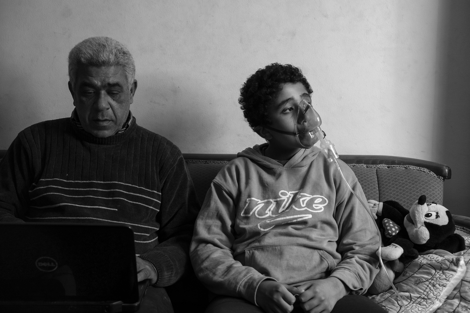 Title: Moon Dust Credit: © Mohamed Mahdy, Arab Documentary Photography Program Caption: Ahmed (11), photographed with his father Saeed, was born with asthma and uses a ventilator three times a day. He plays goalkeeper in football as it requires less physical strain. Alexandria, Egypt, 31 January 2017. Story: More than 30,000 residents of Wadi El-Qamar, also known as Moon Valley, in western Alexandria, Egypt, live less than 15 meters from a cement factory that fills their homes with toxic dust. Children are born with asthma. Families suffer from lung disease and irreversible respiratory damage. In 2016, the photographer – who lives nearby and has asthma himself – began documenting their stories and ongoing legal battles.