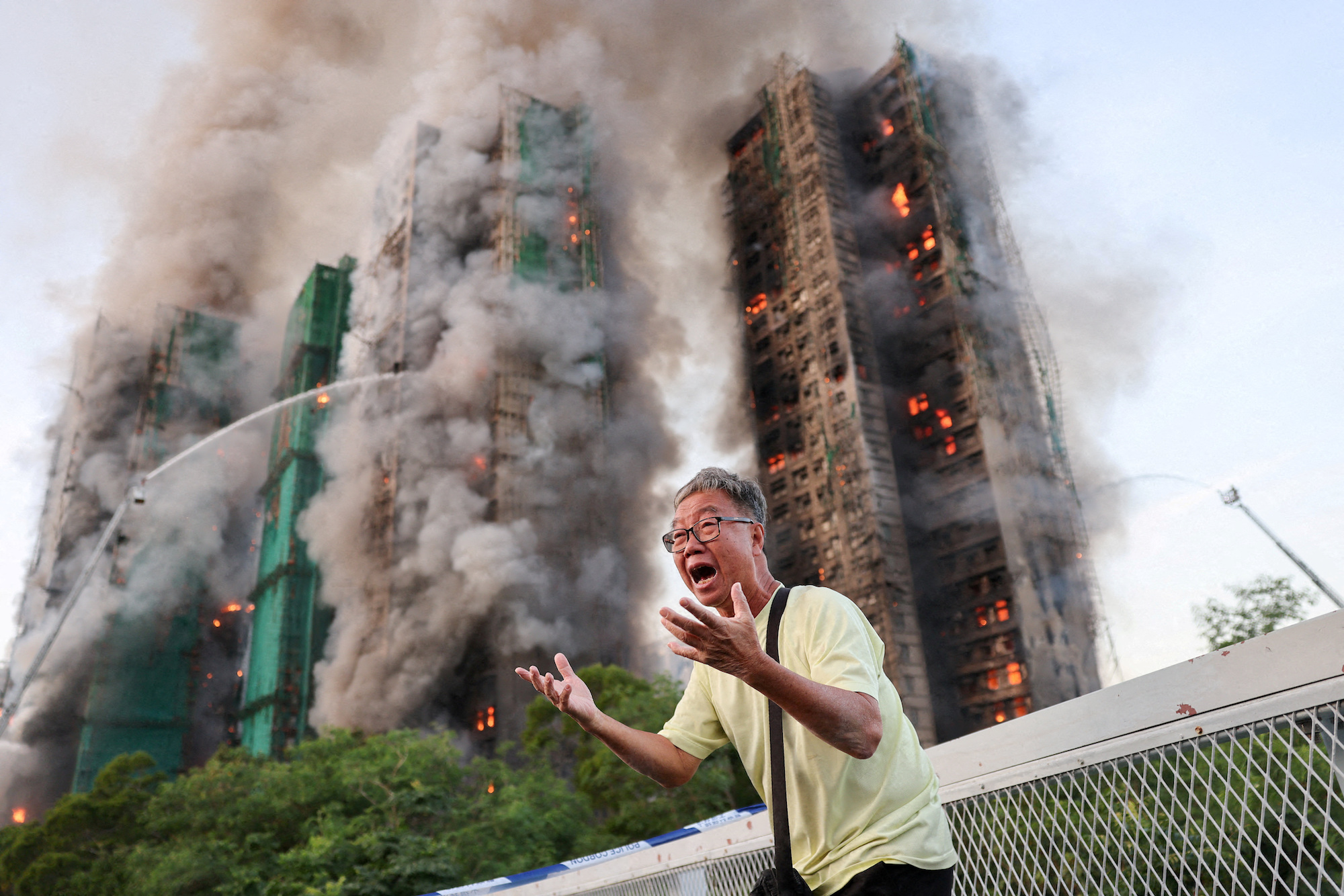 Title: A Desperate Plea Credit: © Tyrone Siu, Reuters Caption: Mr Wong cries out in anguish as fire engulfs the Tai Po housing complex he calls home. Moments earlier, he phoned his wife, who was trapped in the building, and they exchanged what would be their final words. Hong Kong, 26 November 2025. Story: A massive fire at the Wang Fuk Court housing complex in Tai Po claimed 168 lives, becoming Hong Kong’s deadliest fire since 1948. While no official cause has been reported, investigations by Hong Kong authorities found that bamboo scaffolding, construction netting, and flammable Styrofoam boards on windows acted as accelerants for the fire, trapping residents inside. More than 2,000 firefighters were involved in rescue efforts, killing one and injuring twelve.