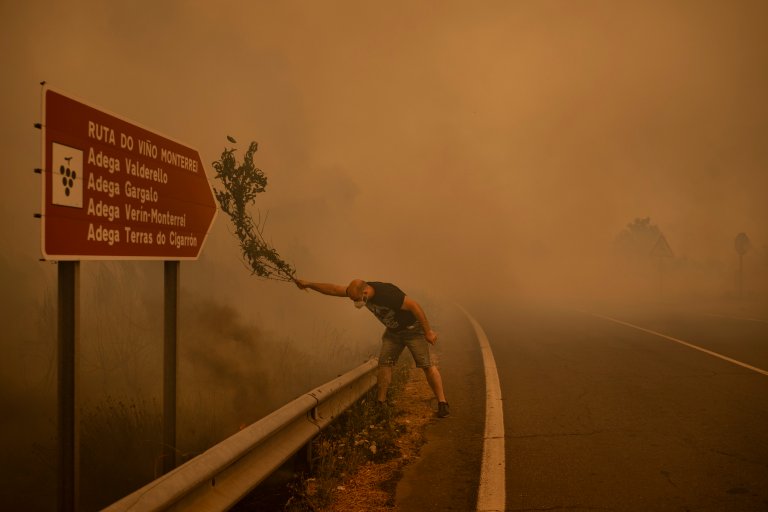 Title: Burned Land Credit: © Brais Lorenzo, EFE, Revista 5W, El País Caption: A man fights a wildfire with a branch in Cualedro. When resources are stretched, residents use whatever is available to extinguish flames, including branches, farming tools, and water hoses. Ourense, Galicia, Spain, 15 August 2025. Story: 2025 was a record year for wildfires in Europe. More than 200,000 hectares burned across Galicia during Spain’s worst fire season in about three decades. The increasingly severe fires in this region are attributed to drought and heat intensified by climate change, rural depopulation, and shortsighted forest management policies, including the widespread planting of highly flammable non-native species. Born in Ourense, the photographer grew up with the smell of smoke every summer and has documented Galician wildfires since 2011.
