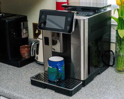 De'Longhi PrimaDonna Aromatic automatic espresso machine on a counter with a mug on it