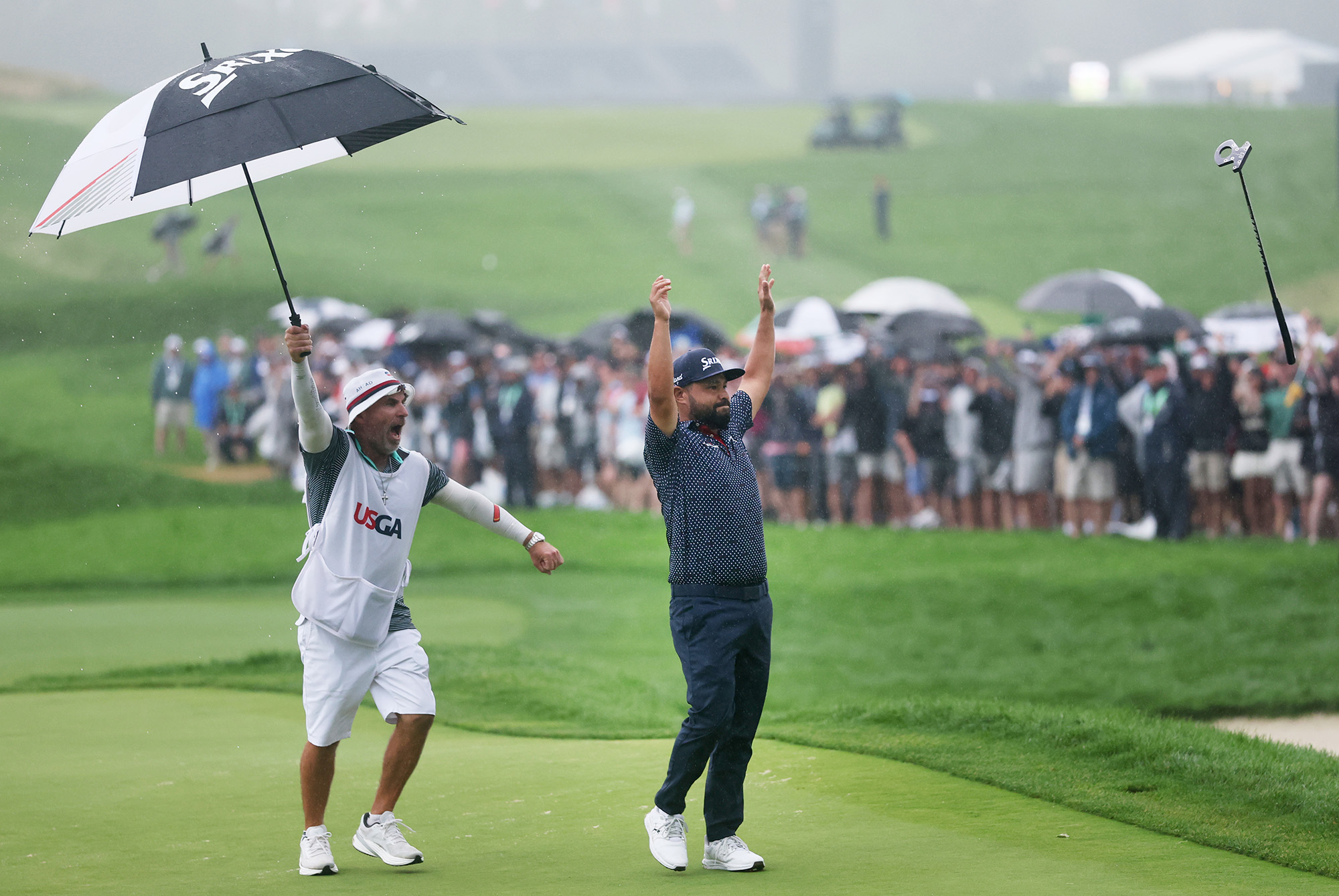 J. J. Spaun shown raising his arms in celebration, his caddy shouting in excitement, after sinking the winning putt at the United States during the final round of the 125th U.S. OPEN at Oakmont Country Club. His custom L.A.B. Golf DF3 putter is seen in mid-air.