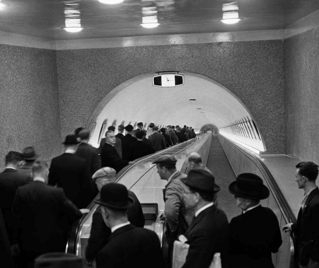 Commuters using the newly installed 'Trav-O-Lator' moving walkway at Bank underground station in London on October 8th, 1960. Black and white image.