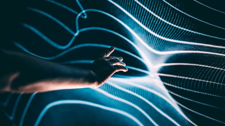 A human arm and hand reaching toward the dark unknown, the dark matter, a series of bright blue lines. Science fiction becoming reality.