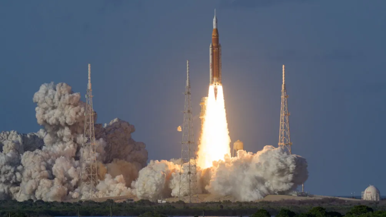 an orange rocket lifting off against a blue sky. puffy white smoke is at its base