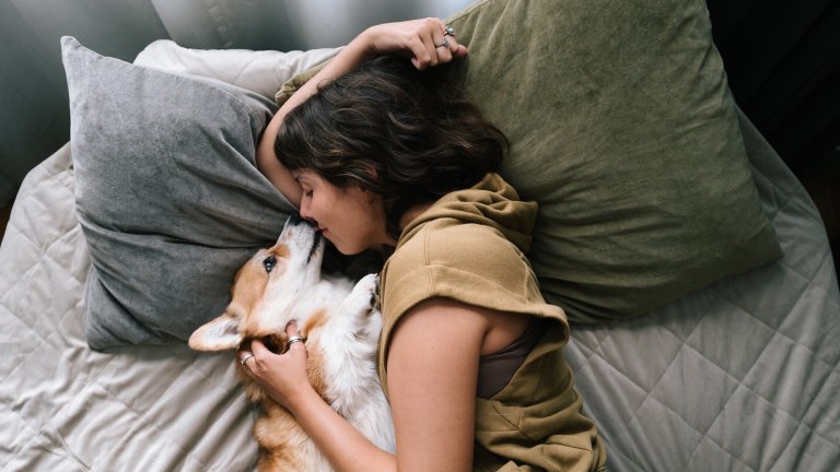 young woman relax Comfortable with cute dog in bed,