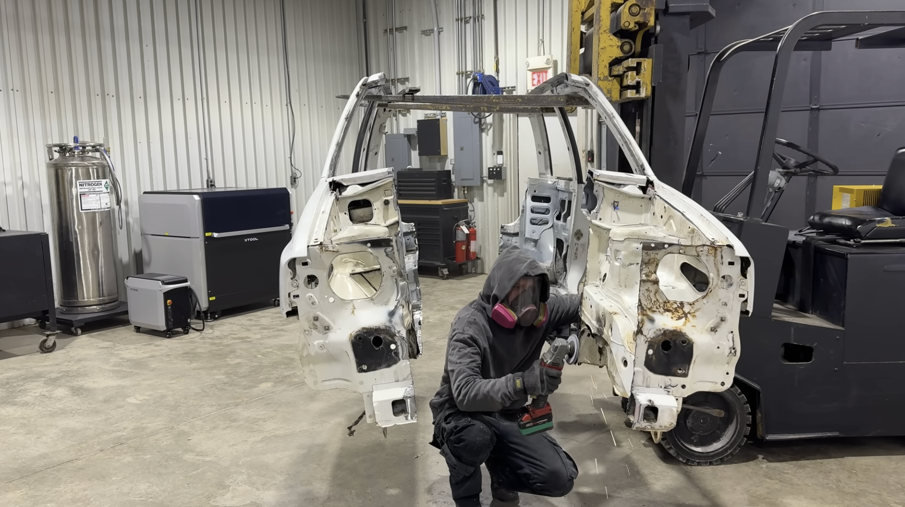 a man wearing a gas mask between a car that's split in half