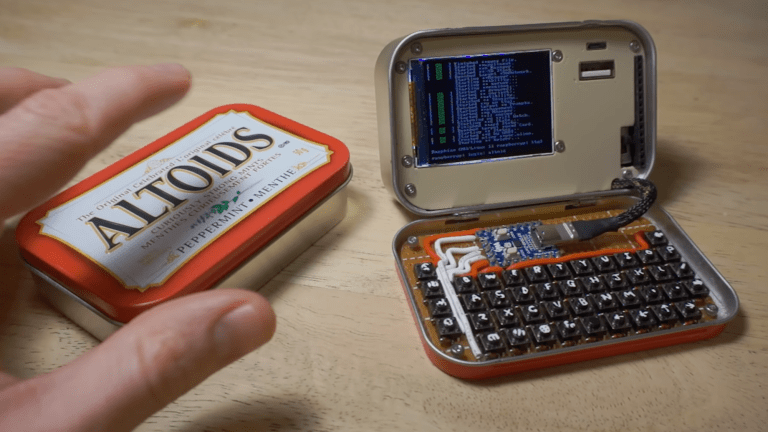 Hand grabbing Altoids tin next to another tin filled with a tiny computer