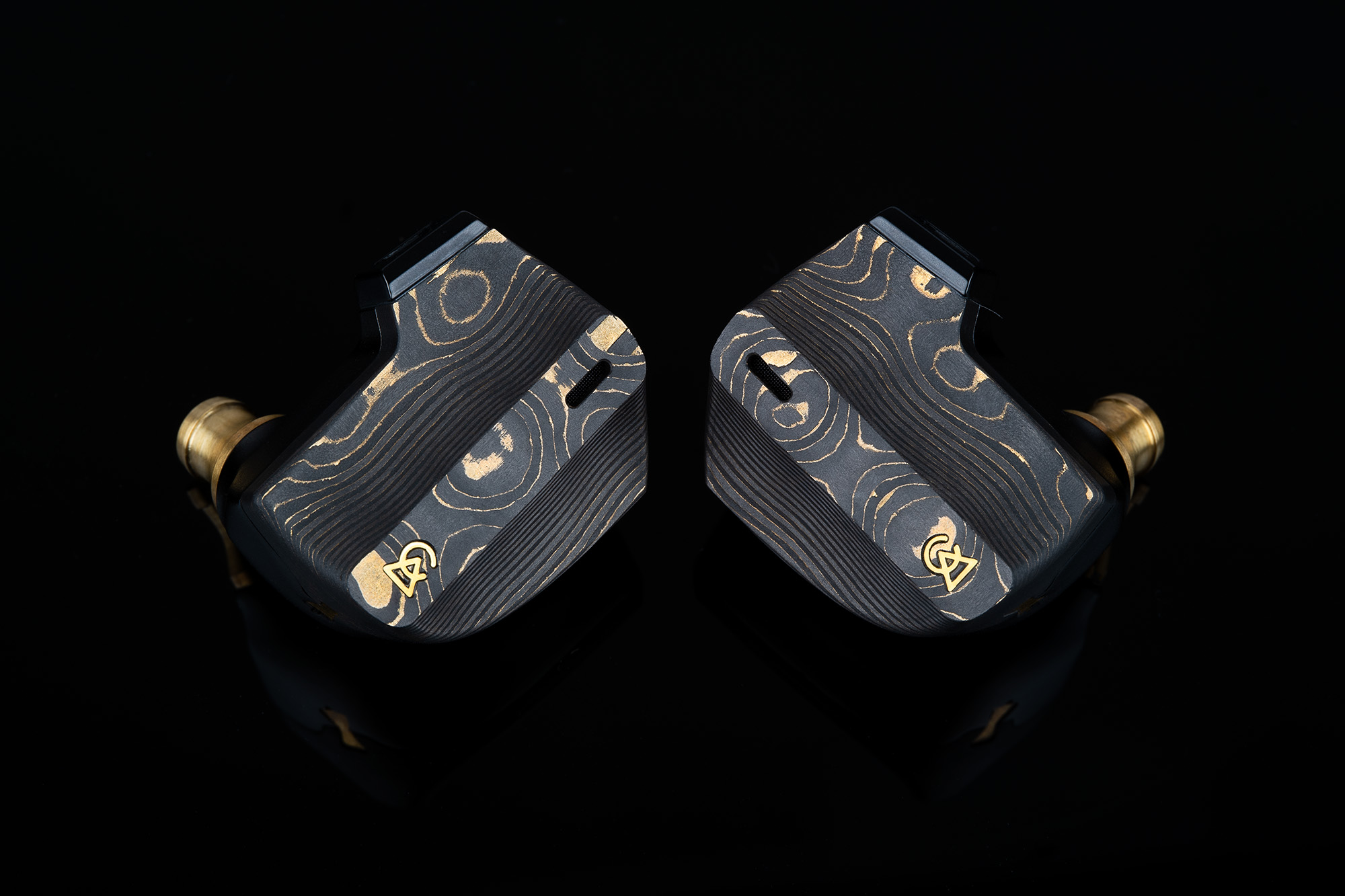 Damascus black Campfire Audio Chimera in-ear monitors shown on a black background