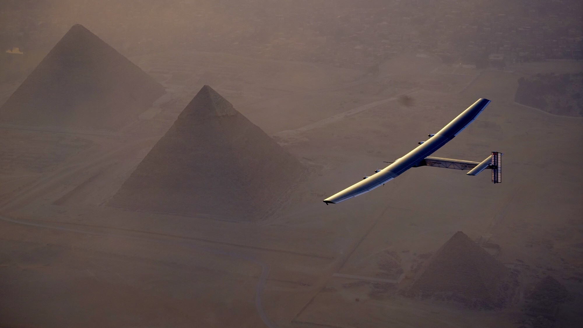 Solar Impulse experimental plane flying over pyramids in Egypt